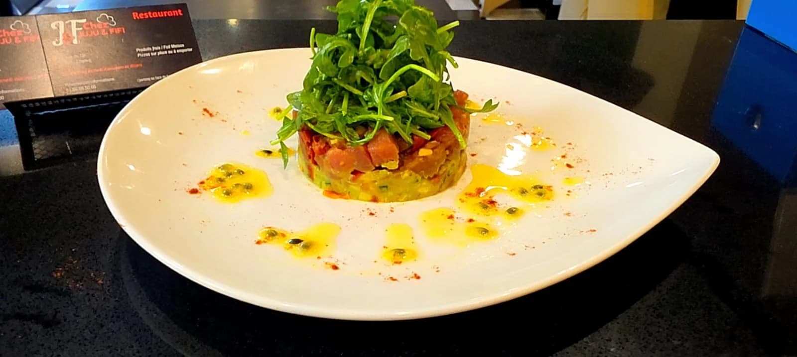 Tartare de thon rouge et avocat servi avec des fruits de la passion